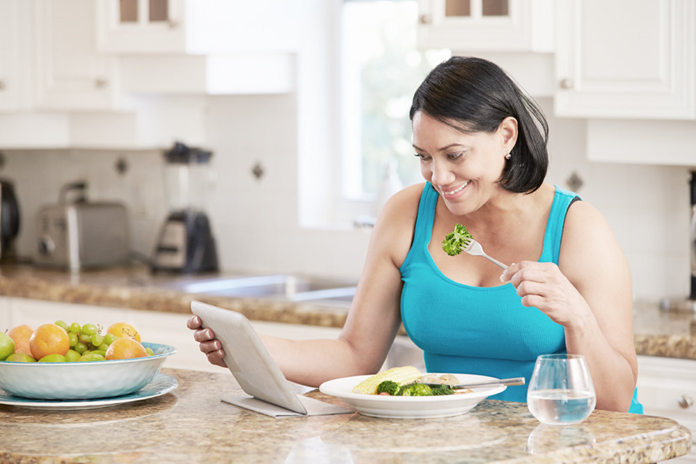 Overweight Woman With Digital Tablet Checking Calorie Intake